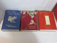 Three Folio Society fairy-tale hardcovers laid out: Grimm, Perrault, Andersen