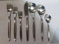 Seven representative utensils laid out: dinner fork, salad fork, dessert fork, dinner knife, soup spoon, tablespoon, teaspoon