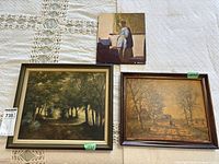 Group shot of two framed landscape paintings and Vermeer print on board