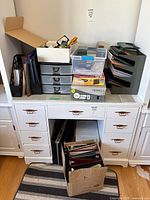 Overview of desk with multiple organizers, binders, trays and storage boxes