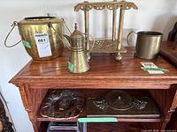 Group of brass teapot, stand, bucket pot and plate on shelf