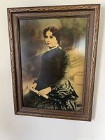 Framed sepia portrait photograph on wall