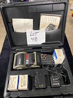 Open carrying case showing printer, accessories, manuals, batteries and label boxes