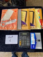 All items laid out: numeric and alphabetic index dividers, report covers, clear file, poly envelope, calculator