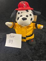 Front view of Dalmatian plush in yellow coat and red hat