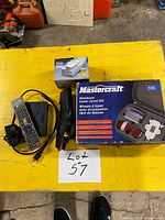 All four items on tabletop: boxed Mastercraft laser level kit, boxed Conair power converter, Dymo label maker, Extreamz IPTV box with remote and cable