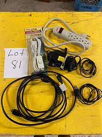 All cords and power bar arranged on yellow surface showing quantity and condition