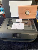 HP Envy 4520 printer-scanner open on flatbed with brown iPad cover resting on lid