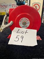 Front view of red Ametek Rota-Reel static discharge reel showing label and attached grounding clamp