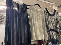 Front view of three tops on hangers