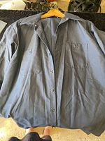 Front view of dark blue work shirt showing button front and pockets