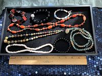 Tray showing all nine beaded jewellery pieces with ruler for scale