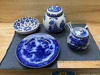 All four blue and white ceramic pieces displayed