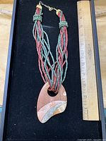 Full view of necklace with ruler for scale