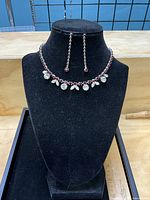 Necklace displayed on bust with earrings hanging, shows overall design and color