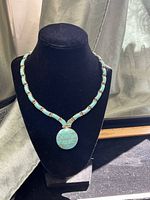 Front view of turquoise and sterling necklace on display bust