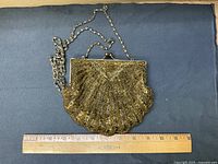 Front view of gold beaded purse with ruler for scale