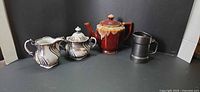 Group shot of all four items: teapot, creamer, sugar bowl, tankard