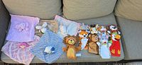 Full lot overview on sofa showing all security blankets, puppets and plush toys