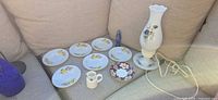 Group shot of lamp, saucers, creamer, plate and figurine