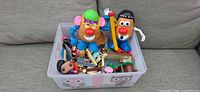 Overall lot showing two Mr. Potato Heads and LEGO pieces in bin