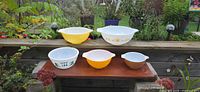 Five mixing bowls displayed outdoors on bench