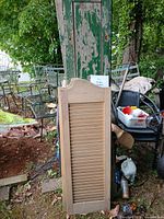 Green solid shutter behind khaki louvered shutter outdoors