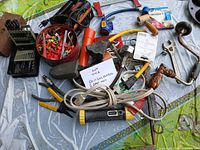 All items spread on tarp showing tools, drill bits, electrical accessories