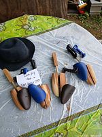 Overall lot view: black hat and four shoe stretchers on table