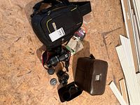 Group view of camera, lenses, bags, accessories on floor