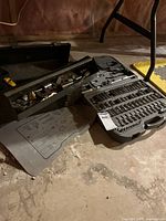 Overview of Craftsman toolbox and molded socket set case on basement floor