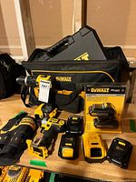 All tools, chargers, batteries, bag, packaged batteries displayed on table