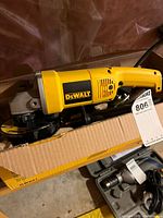 Angle grinder inside open box showing full tool and power cord