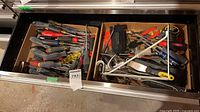 Drawer with two cardboard trays of screwdrivers and other hand tools