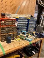 Workbench view showing drawer cabinets, vise, oil can, plastic cases, cords