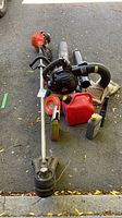 Full view of blower, trimmer, fuel can, oil bottle, trimmer line