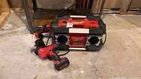 Jobsite radio, reciprocating saw with battery attached, partial view work light