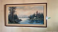 Full view of framed landscape oil painting on wall