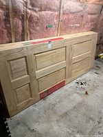 Stack of five pine six-panel doors leaning on floor