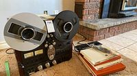 Front angled view of tape deck with both metal reels and stack of tapes