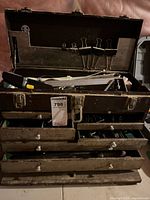 Full view of metal tool chest with drawers open showing contents