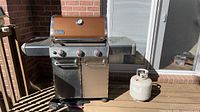 Full view of Weber propane BBQ grill with propane tank
