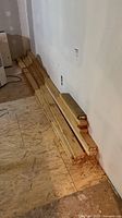 Stack of lumber pieces laid on subfloor against wall