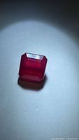 Front view of emerald-cut ruby under spotlight