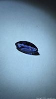Marquise-cut purple-blue gemstone on light background