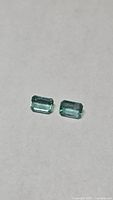 Both emeralds side-by-side showing size and color