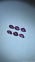 Six oval faceted rubies on neutral background