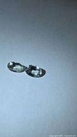 Pair of light green oval faceted tourmaline gemstones on white background
