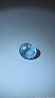 Front view of oval cut aquamarine showing faceted crown and color