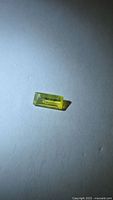 Top view of rectangular yellow chrysoberyl showing color and cut